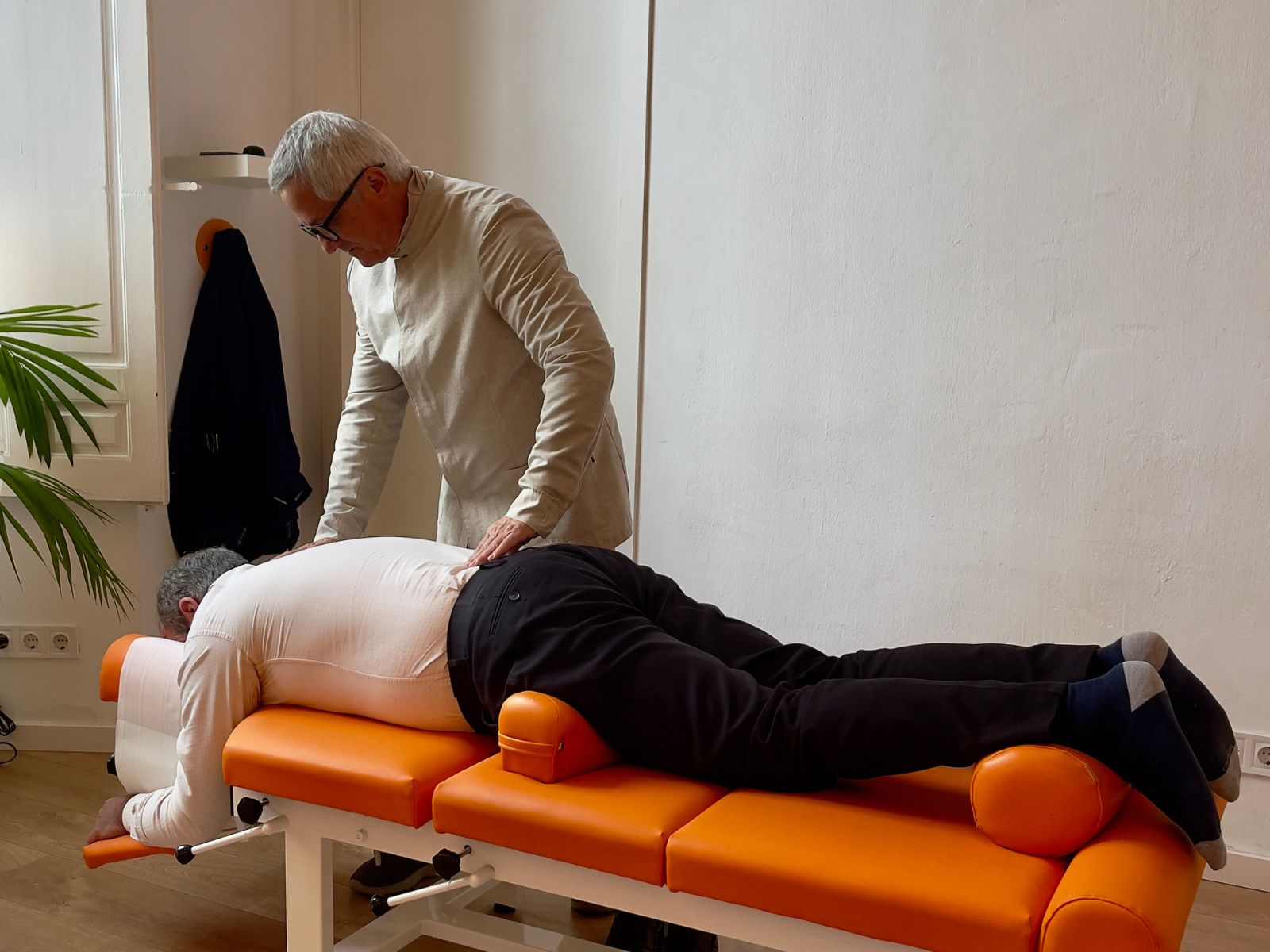 Exploración lumbar con paciente — Tonovital Centro Quiropráctico Málaga José De San Juan Guerrero, Doctor of Chiropractic, explorando la zona lumbar de un paciente en camilla en Tonovital Centro Quiropráctico Málaga
