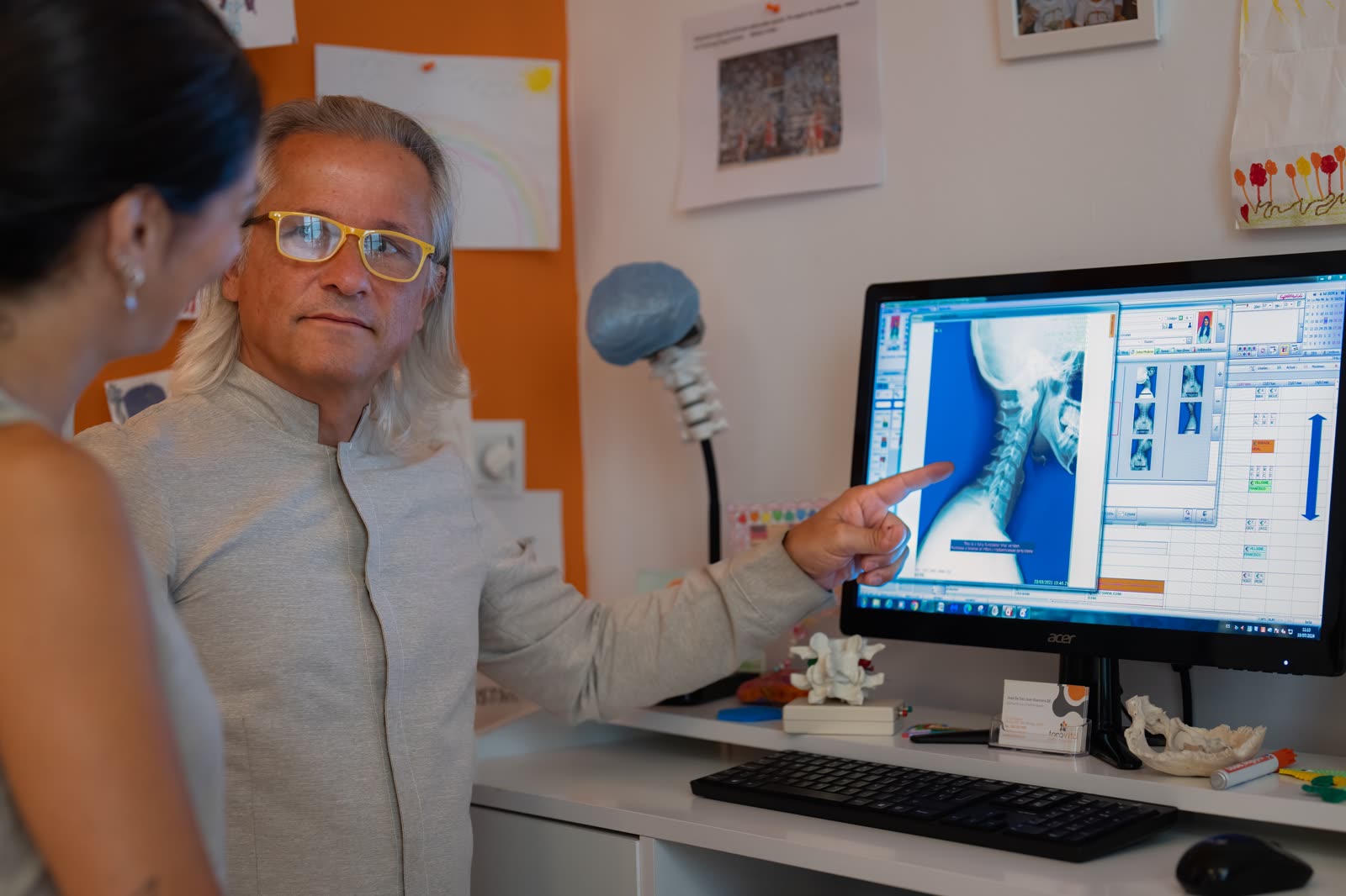 José De San Juan Guerrero, Doctor of Chiropractic, mostrando radiografía lumbar a un paciente en Tonovital Centro Quiropráctico Málaga